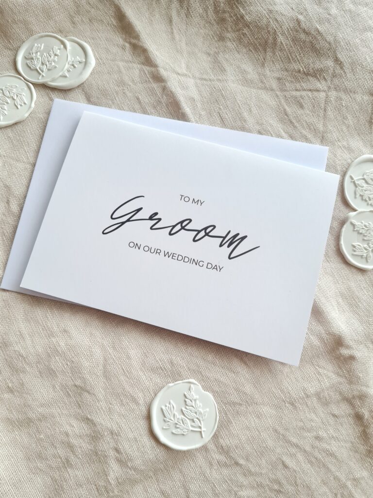 A greeting card with elegant calligraphy that reads "To my Groom on our wedding day". The card has a simple and modern design, with a white background and black text.