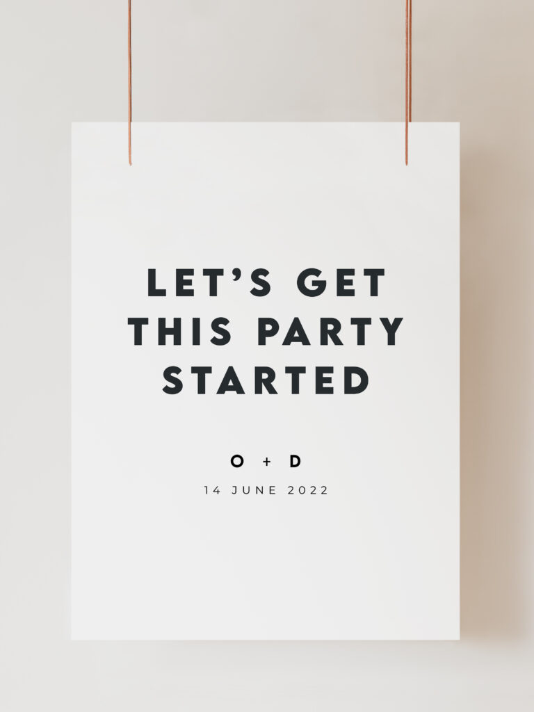 An image of a welcome sign which is black and white and reads 'let's get this party started' with the couples initials and wedding date below in a modern minimalist style. The sign is hanging on ribbon with a beige background behind.