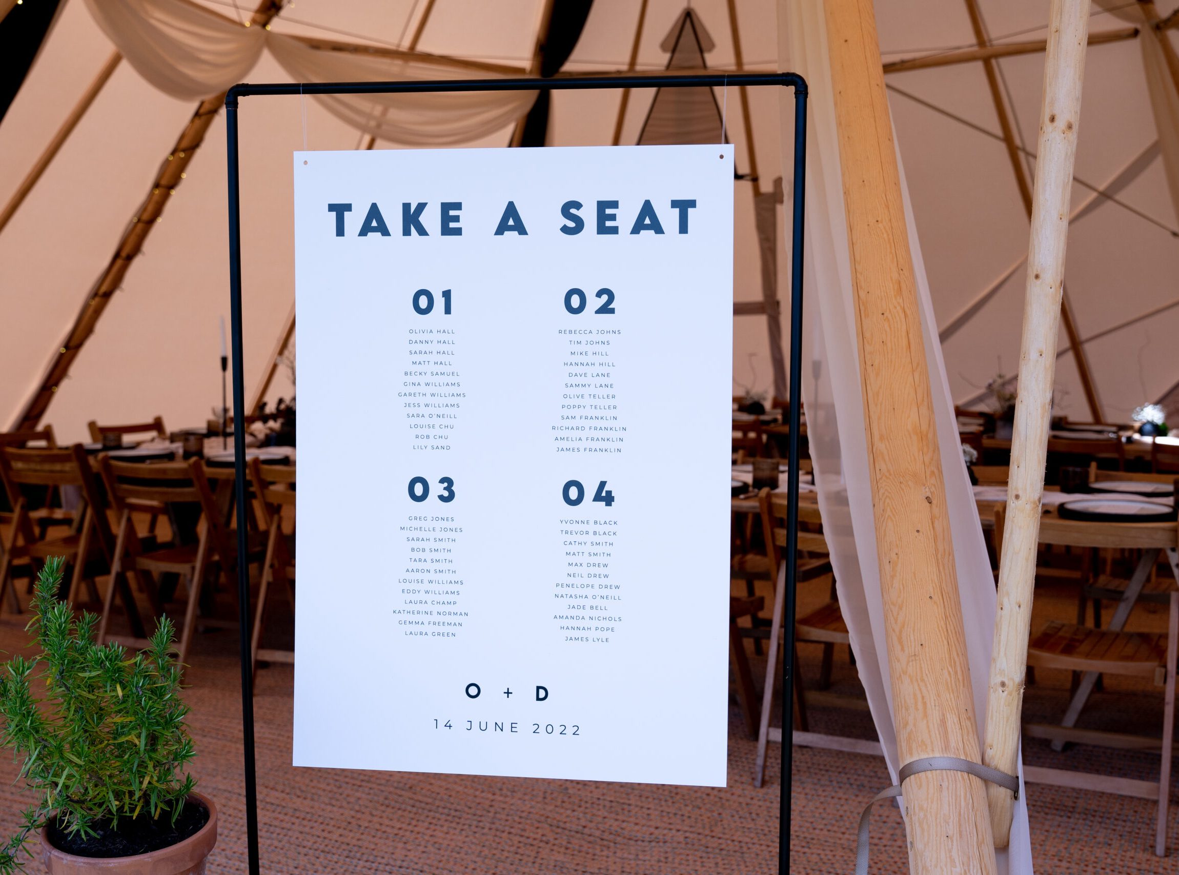 A black and white table plan displayed in a black copper sign frame that reads 'take a seat', taken as part of a styled shoot in Deer Farm Tipi Weddings, Exeter.